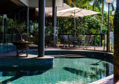 The swimming pool curls around the front of the house